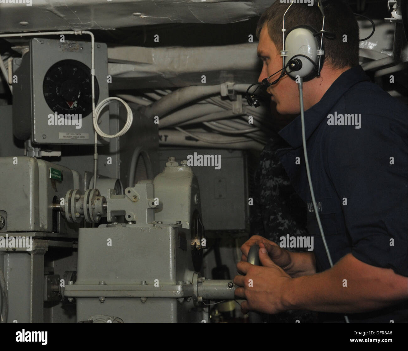 Seaman Kalan lange mans achtern Lenkung während einer Lenkung Unfall Drill auf dem Mehrzweck amphibischer Angriff Schiff USS Bataan Stockfoto