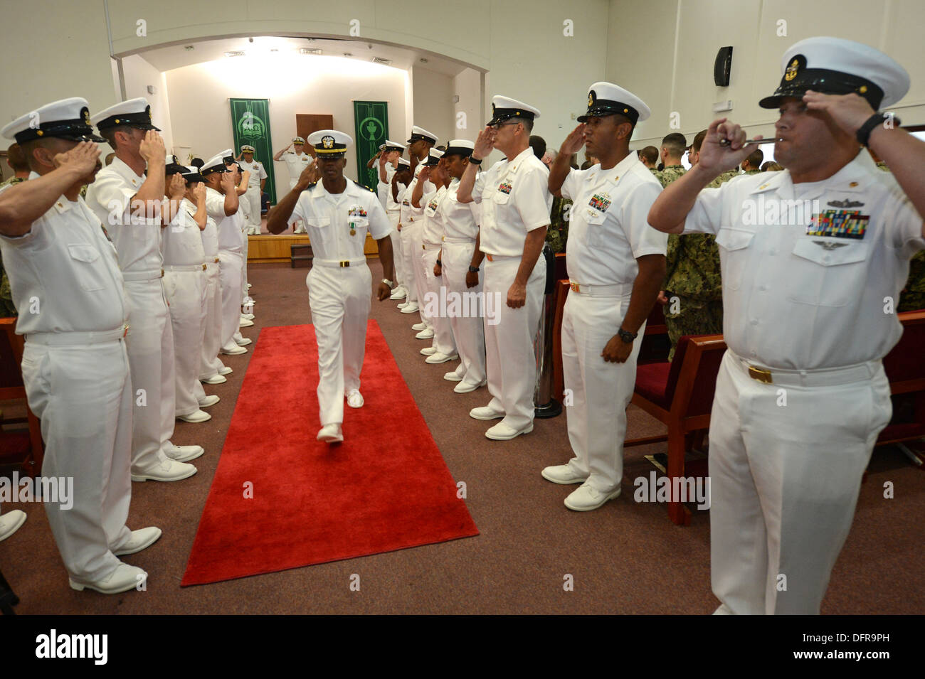 Chief Master-at-Arms Carlos L. Jones, Commander Task Group (CTG-56,7), 56,7 zugewiesen wird an Land geleitet, wie ein frisch gebackenen Ensign in einer Zeremonie am Naval Support Aktivität Bahrain statt. CTG-56,7 führt maritimer Sicherheitsoperationen um Mov zu gewährleisten Stockfoto