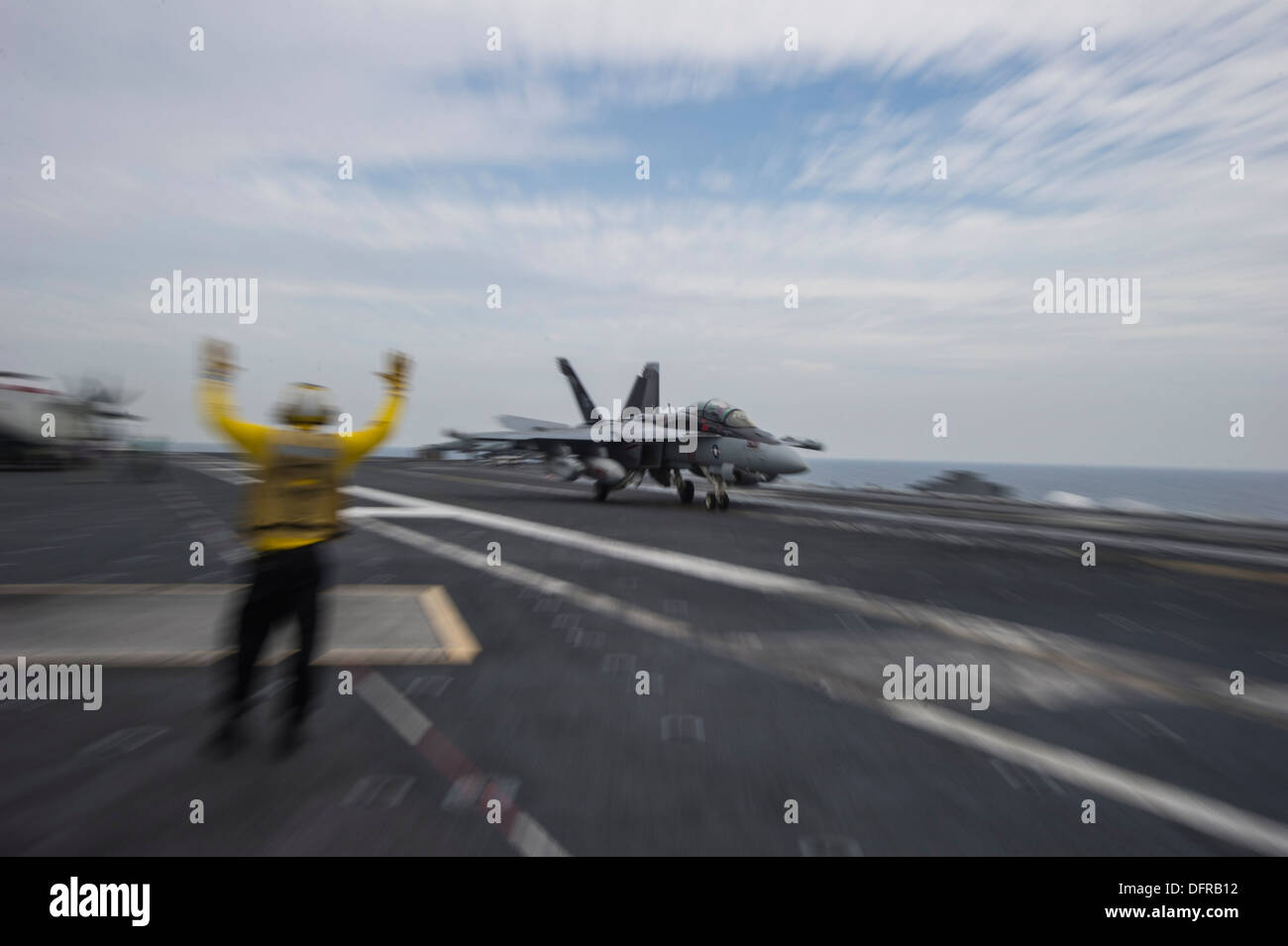 Luftfahrt Boatswain Mate (Handling) 1. Klasse James Whitehead aus Miami, gibt ein Signal an den Piloten eine EA - 18G Growler aus "Schattenfalken" von Electronic Attack Squadron (VAQ) 141 nach einer verhafteten Landung auf dem Flugdeck der US Navy für Stockfoto