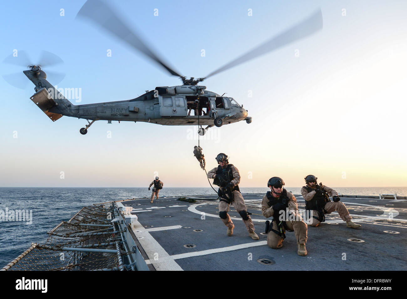 Küste Gardisten Advanced Interdiction Team 4 schnell Seil von einem MH-60 Seahawk Hubschrauber zu der Wüste Falken der Hubschrauber Meer bekämpfen Squadron (HSC) 26 auf dem Flugdeck der geführte Flugkörper Kreuzer USS Monterey (CG-61) während einer t zugewiesen zugewiesen Stockfoto