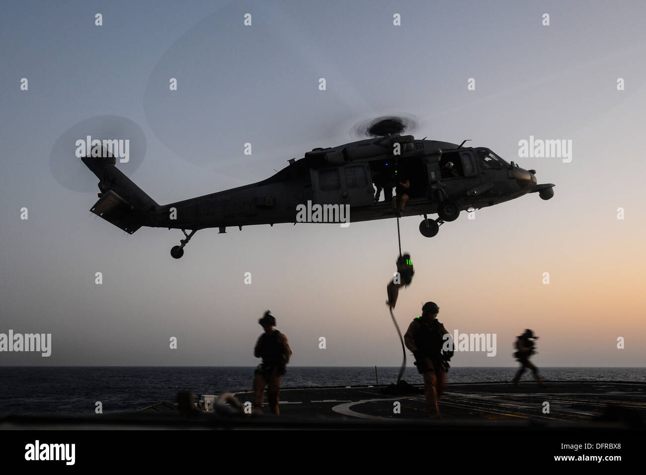 Küste Gardisten Advanced Interdiction Team 4 schnell Seil von einem MH-60 Seahawk Hubschrauber zu der Wüste Falken der Hubschrauber Meer bekämpfen Squadron (HSC) 26 auf dem Flugdeck der geführte Flugkörper Kreuzer USS Monterey (CG-61) während einer t zugewiesen zugewiesen Stockfoto