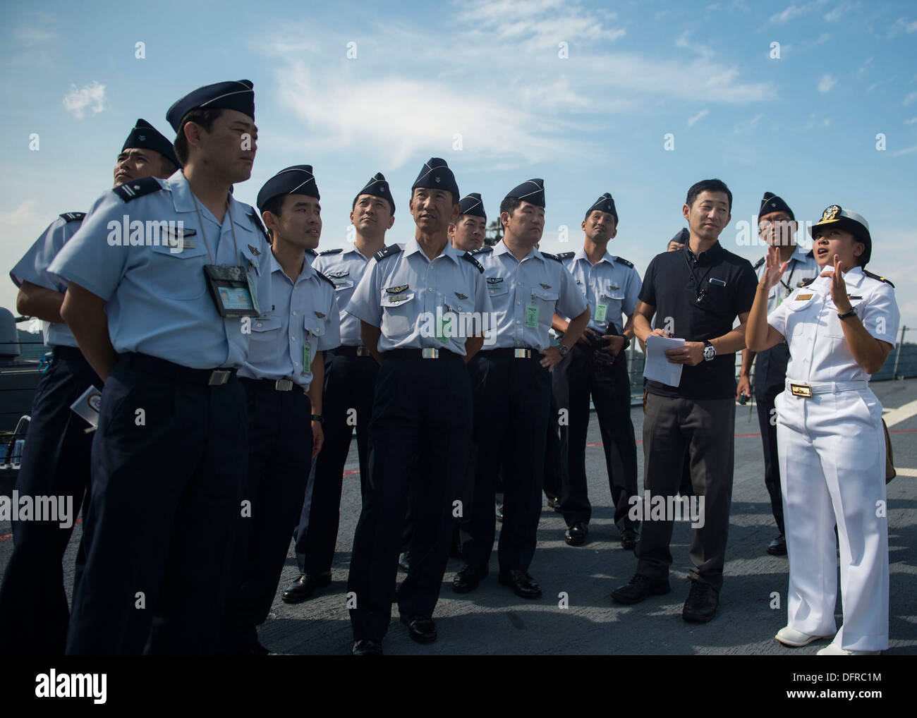 Ensign Isabel Gomez, Recht, erklärt die Phalanx schließen-in Waffen-System (CIWS) Mitgliedern der Japan Air Self-Defense Force während einer Schiffstour an Bord der geführte Flugkörper-Zerstörer USS Stethem (DDG-63). Stethem vorwärts nach Yokosuka, Japan bereitgestellt wird und Stockfoto