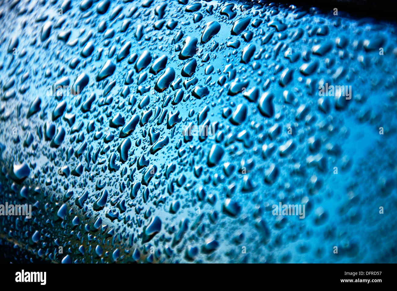 Regentropfen auf Metall Autotür Stockfoto