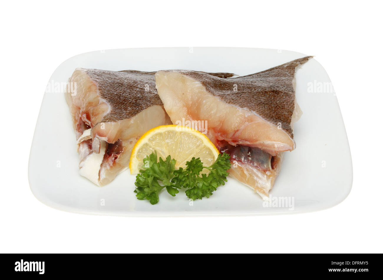 Brill Fisch Steaks auf einer Platte mit Zitrone und Petersilie isoliert gegen weiß Stockfoto