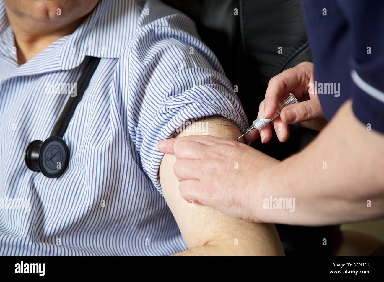 Krankenschwester bereitet sich auf die Grippe Jab Injektion zu einem Arzt-GP. Stockfoto
