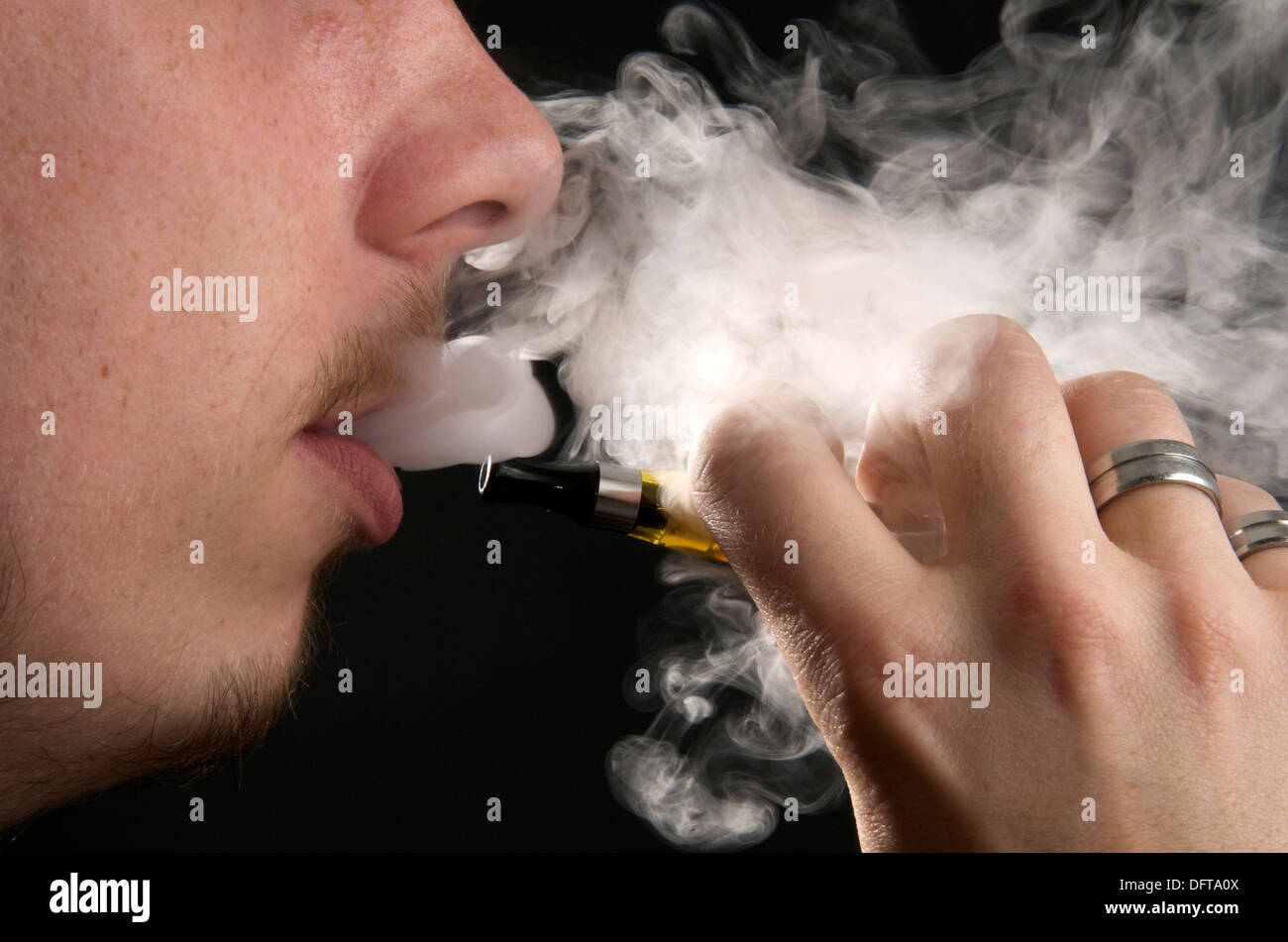 Mann vaping Rauchen eine elektronische e-Zigarette und atme den Rauch Stockfoto