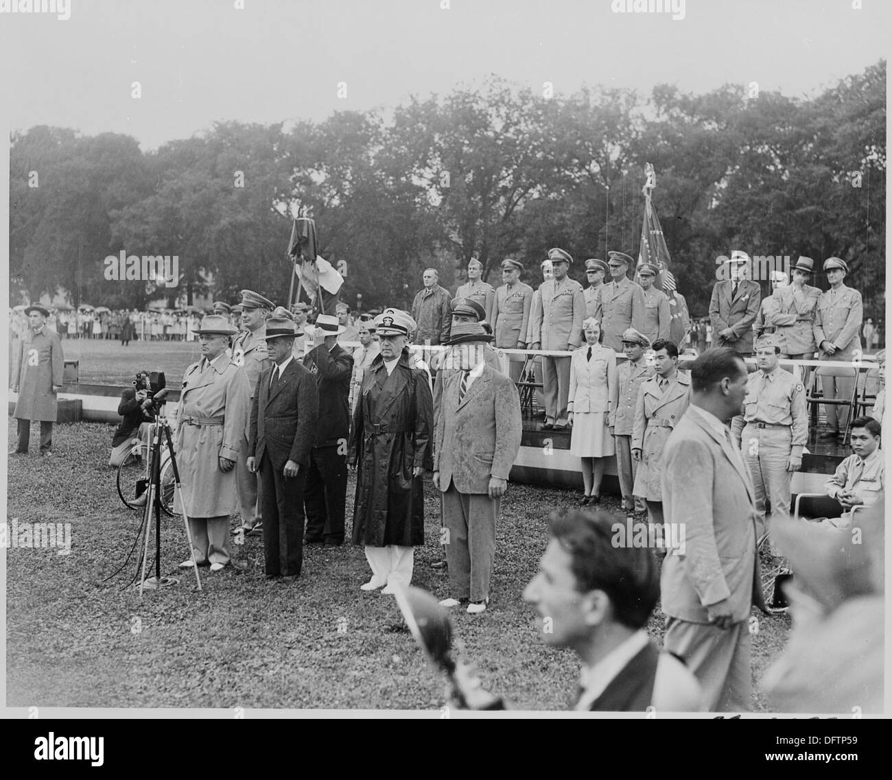 Ein Foto von Präsident Truman und Würdenträgern, die im Regen stehen und das 442. Regimentskampfteam, eine der am meisten dekorierten Einheiten im Zweiten Weltkrieg, betrachten. Stockfoto