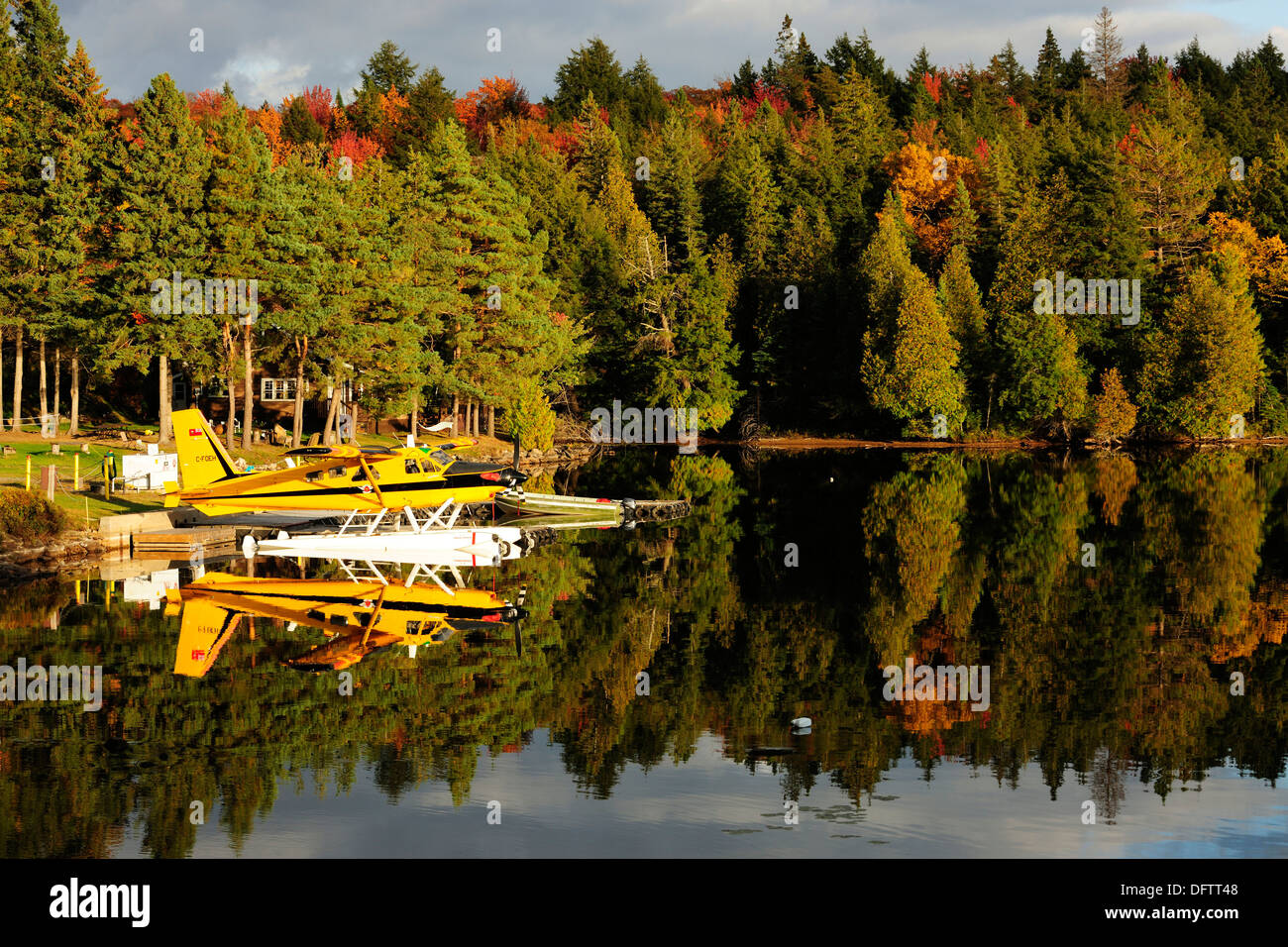 Wasserflugzeug auf Rauch See vor ein Blockhaus im Herbst gefärbten Wald, Algonquin Provincial Park, Ontario Provinz Stockfoto