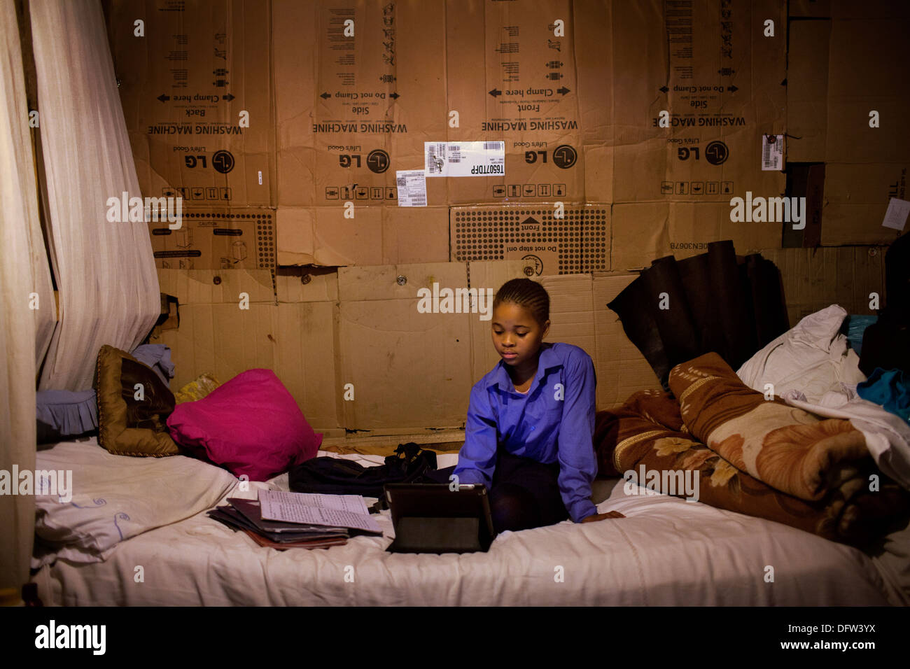Phelela, 13 Jahre alt, Hausaufgaben auf einem iPad in ihrem Schlafzimmer in Nyanga, Cape Town, Südafrika Stockfoto