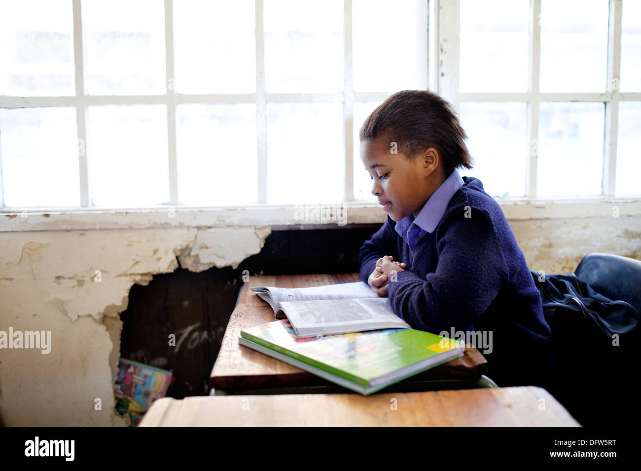Afrikanischen Schülerin liest ein Lehrbuch in der Klasse in der Thandokhulli Schule, Mowbray, Kapstadt. Stockfoto