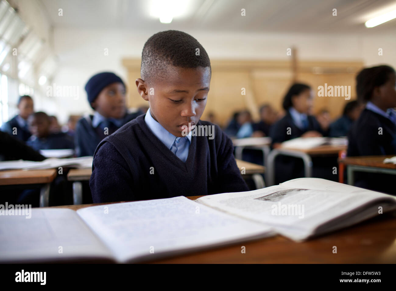 Afrikanische Schüler liest ein Lehrbuch in der Klasse in der Thandokhulli Schule, Mowbray, Kapstadt. Stockfoto
