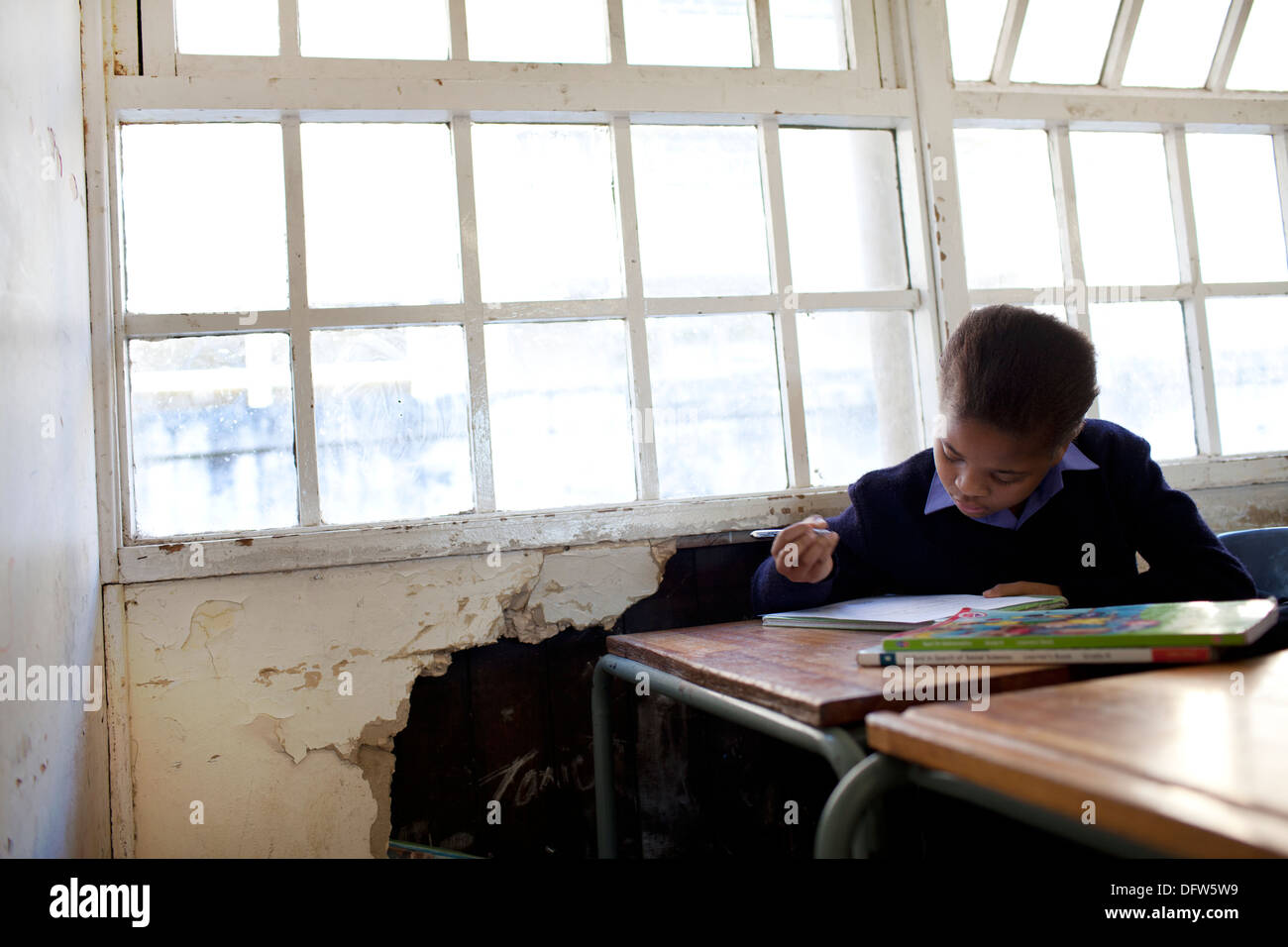 Afrikanischen Schülerin liest ein Lehrbuch in der Klasse in der Thandokhulli Schule, Mowbray, Kapstadt. Stockfoto