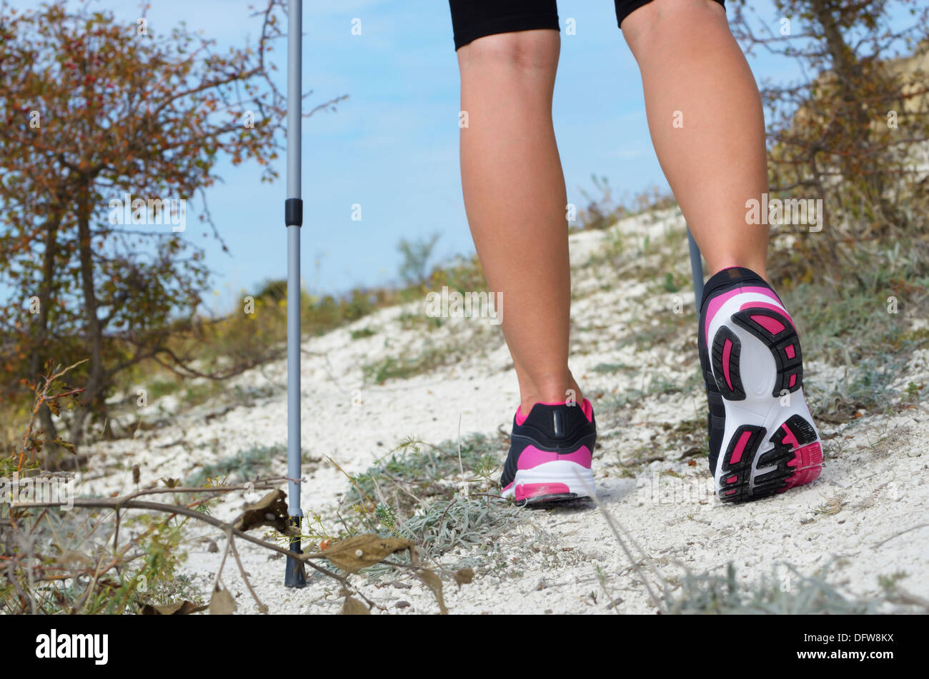 Weibliche Füße und trekking-Stick auf dem Weg Stockfoto