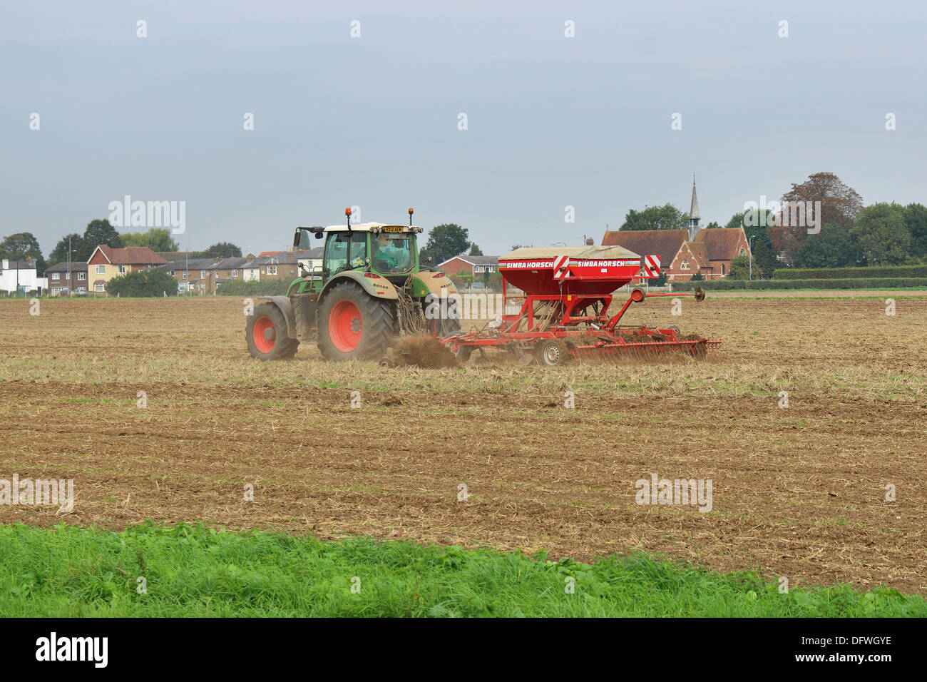 Traktor-Tilling und Düngung ein Feld in England Stockfoto
