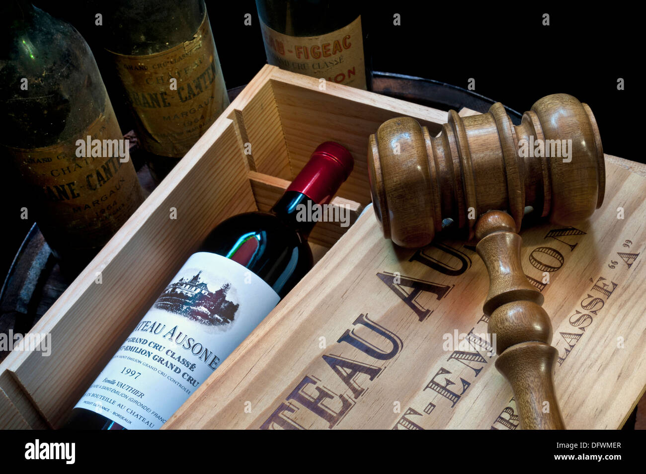 Versteigerung von erlesenen Weinen mit Gavel auf offener Kiste von Chateau Ausone Saint-Émilion und anderen älteren edlen Bordeaux-Weinflaschen hinter Frankreich Stockfoto