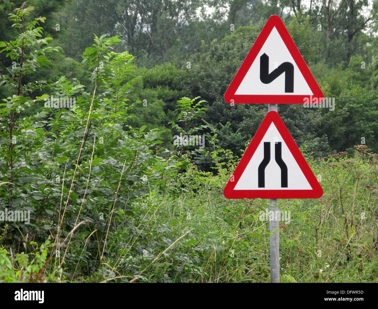 Rotes Dreieck Vorsicht und Achtung Verkehrszeichen für eine Verengung  Straße und kurvenreiche Straße, UK Stockfotografie - Alamy