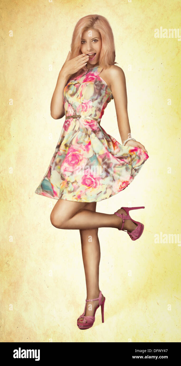 Ein Mädchen in einem geblümten Kleid und high Heels in eine Retro-Pin-Up style UPS pose Stockfoto