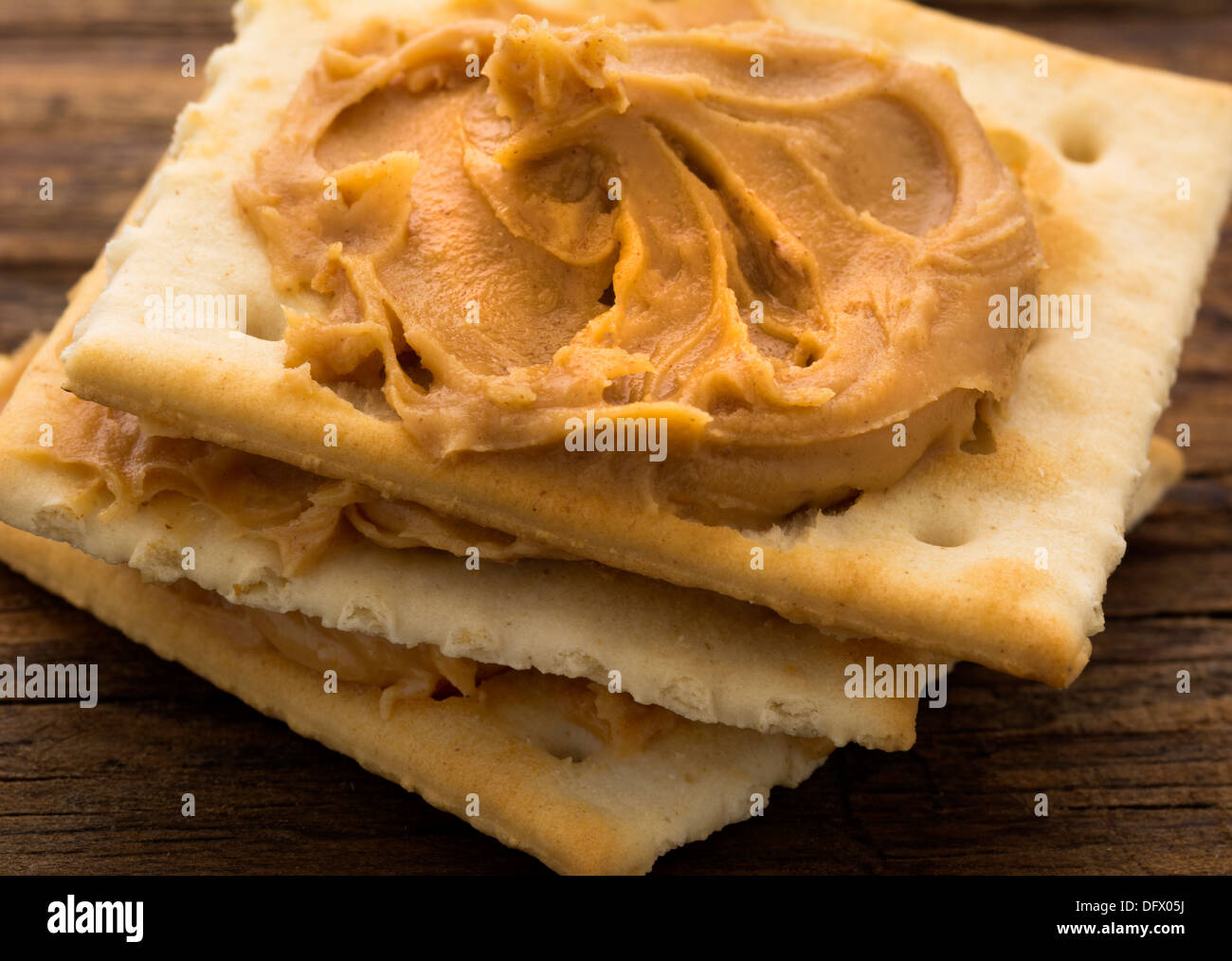 Erdnussbutter auf Cracker auf verwitterten plank Stockfoto