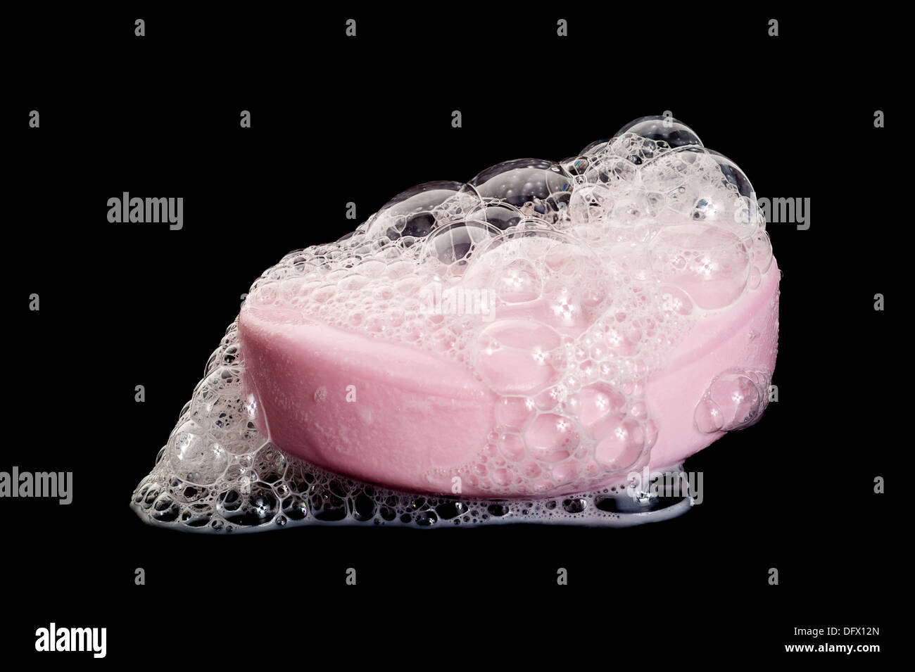 Ein Stück Seife mit Seifenblasen auf dunklem Hintergrund Stockfoto