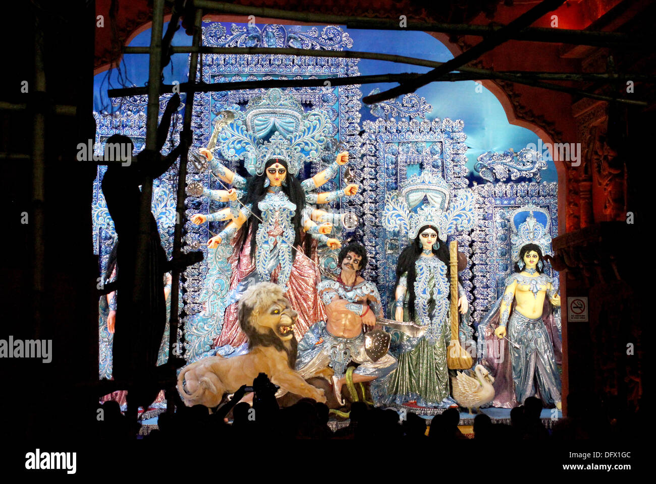 Kolkata, Indien. 7. Oktober 2013. Ein Arbeiter entfernt einen Bambus-Rahmen vor einer Statue der hinduistischen Göttin Durga während der Durga Puja Festival in Kalkutta, Indien, 7. Oktober 2013. Noch viele Frauen sind von der Gesellschaft nach dem Tod ihres Mannes gewirkt. Foto: DOREEN FIEDLER/Dpa/Alamy Live News Stockfoto