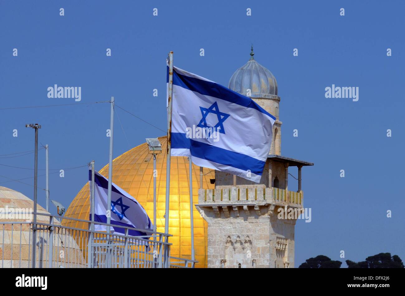 Blick auf einer israelischen Flagge auf der Dachterrasse vor der Kuppel des Rock und eine Moschee in der Altstadt von Jerusalem, Israel, 10. September 2013. Jerusalem ist die Heilige Stadt für alle drei monotheistischen Religionen; Juden, Muslime und Christen haben einige der ihre Heiligtümer hier. Der Felsendom auf dem Tempelberg ist ein achteckiges Gebäude von Umayyad Ära. Es deckt den Felsen aus, den, muslimischen Überlieferung Mohammed in den Himmel aufgefahren und trafen sich die ehemaligen Prophet des Judentums und Jesus. Nach der biblischen Überlieferung ist dies der Ort, wo Abraham seinen Sohn Isaak opfern wollte. Die Stockfoto