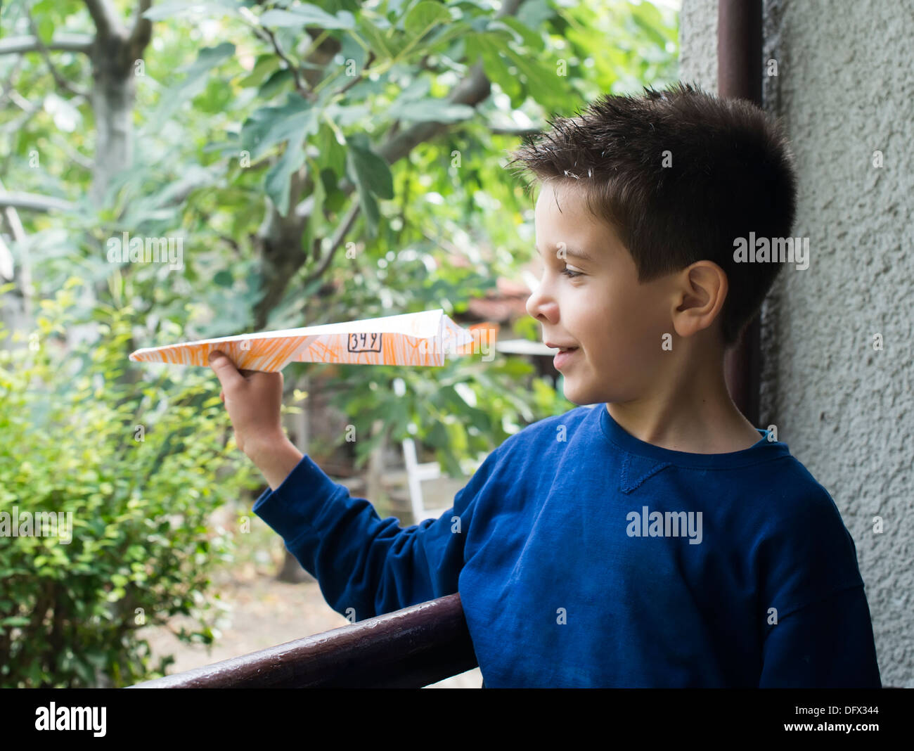 Kind wirft Papierflieger. Authentisches Bild Stockfoto