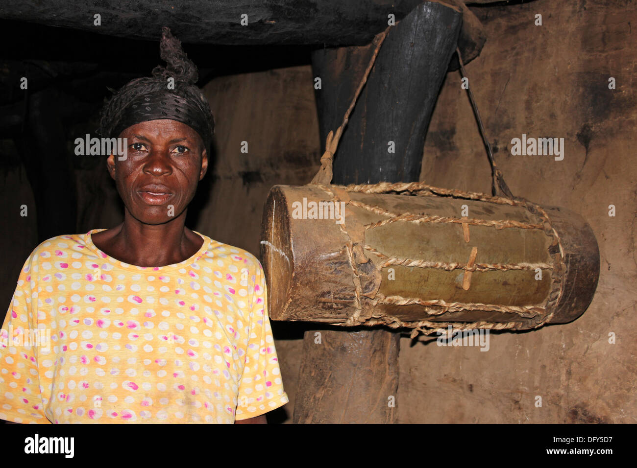 Reife Lobi Frau stehend neben traditionellen Trommel ihrer Hütte Stockfoto