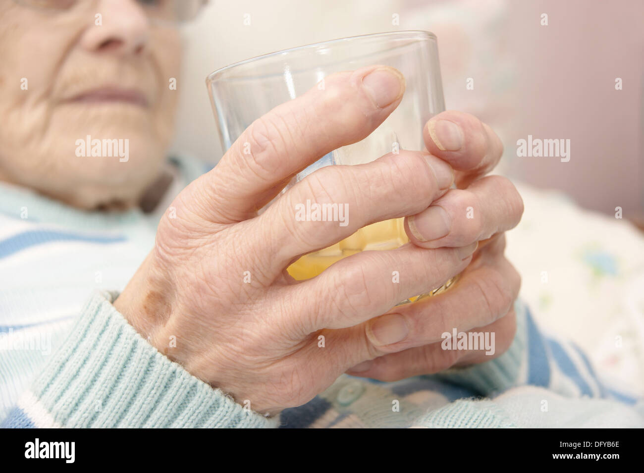Ältere Frau Patienten mit einem Glas Orangensaft mit einem Getränk Stockfoto