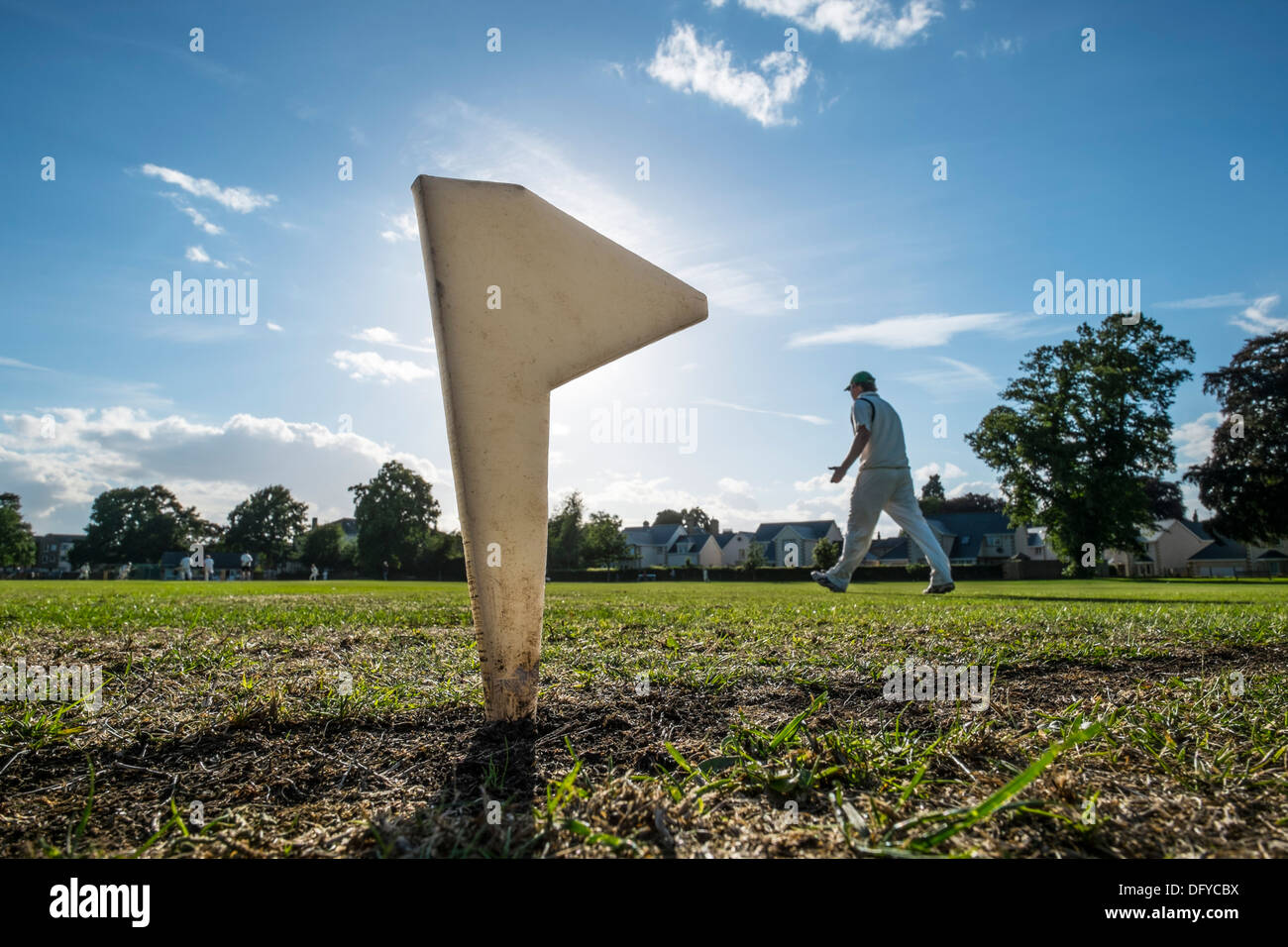 Cricket Pitch Grenze Marker mit Spiel spielte darüber hinaus in Ferne, Fielder zu Fuß Stockfoto