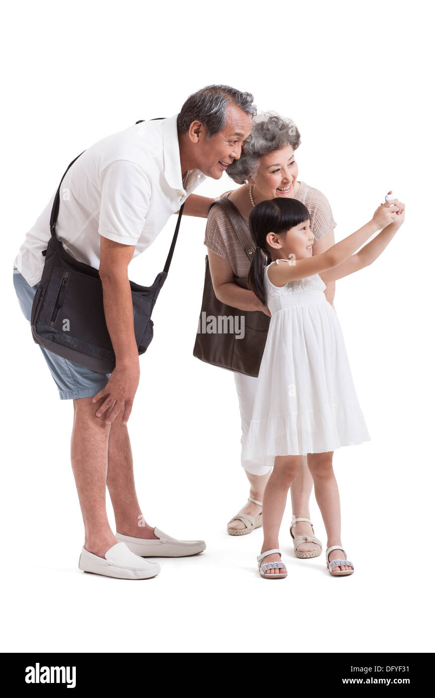 Glückliche Großeltern und Enkelin mit dem Smartphone fotografieren Stockfoto