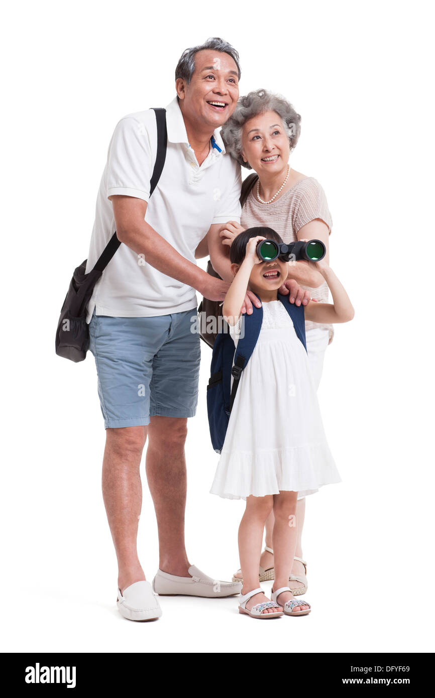 Freudige Großeltern und Enkelin mit dem Fernglas Stockfoto