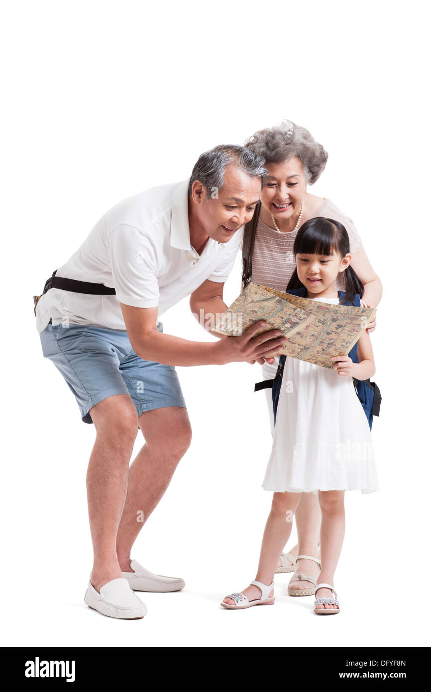 Glückliche Großeltern und Enkelin mit Karte Stockfoto