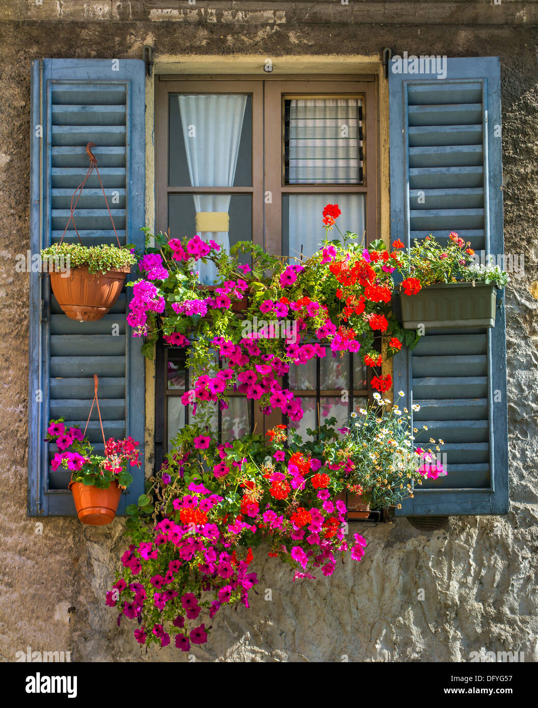 Vintage-Fenster mit offenen Fensterläden aus Holz und frische Blumen Stockfoto