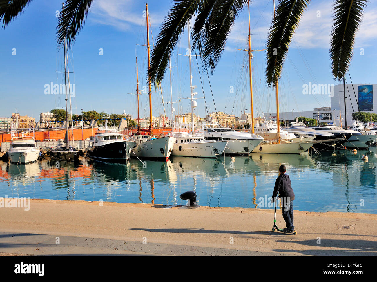 Barcelona, Katalonien, Spanien. Port Vell. Junge mit Roller von der waterfront Stockfoto