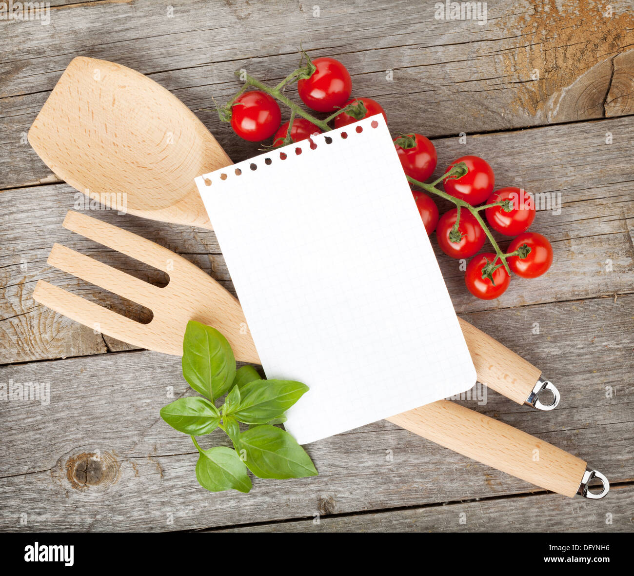 Leere Notizblatt Papier für Ihre Rezepte mit Tomaten und Basilikum auf Holztisch Stockfoto