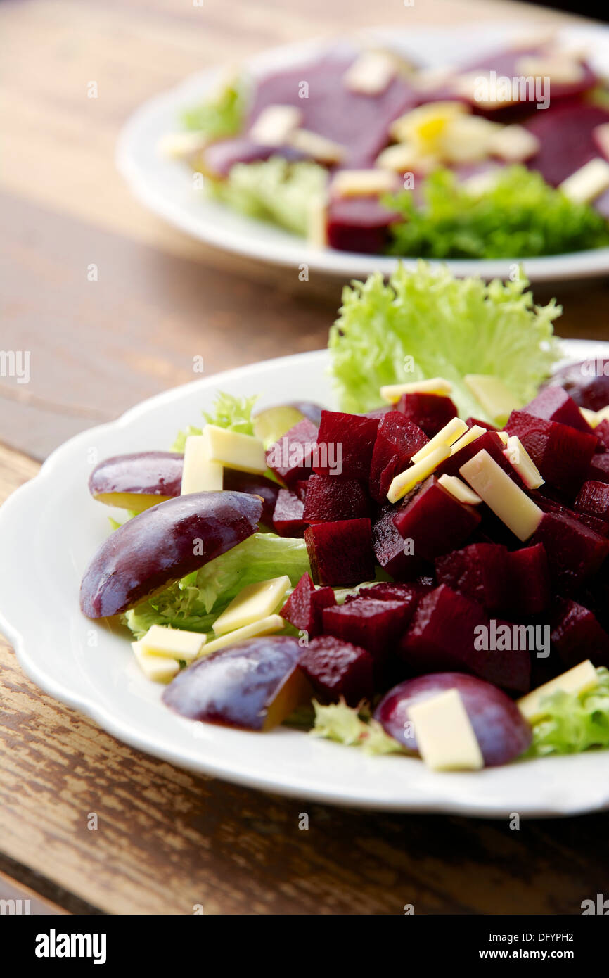 Rote Rüben, Pflaumen, veganen Käse auf Lollo Bianco Salatbett. Dressing aus Balsamico-Essig mit schwarzer Johannisbeere Sirup. Stockfoto