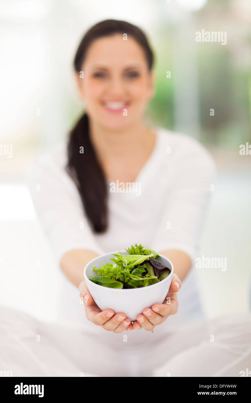 glücklich schwanger Frau hält Schüssel mit grünem Salat Stockfoto