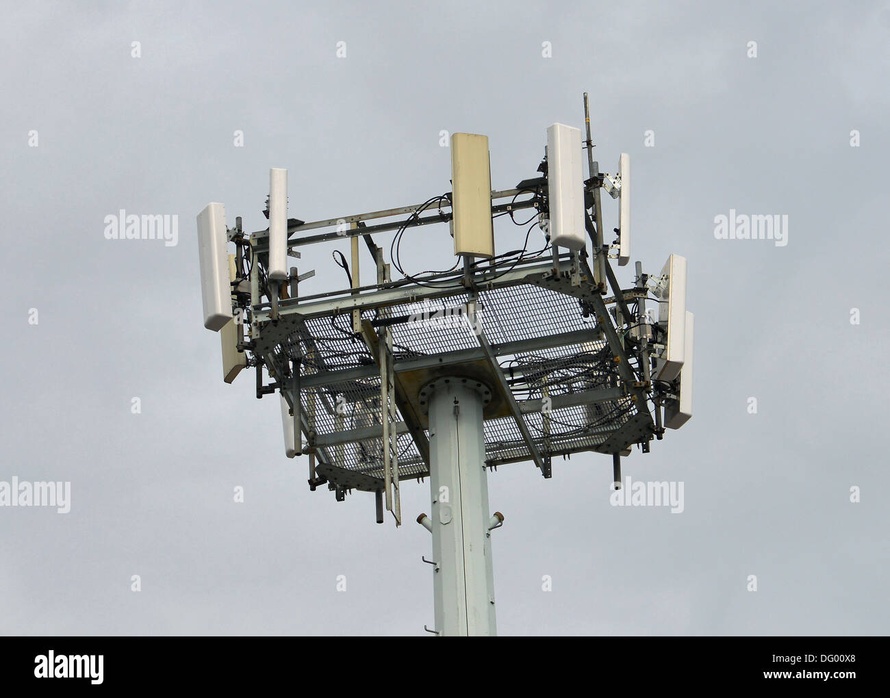 Oben ein Mobilfunkmast vor einem grauen Himmel. Stockfoto