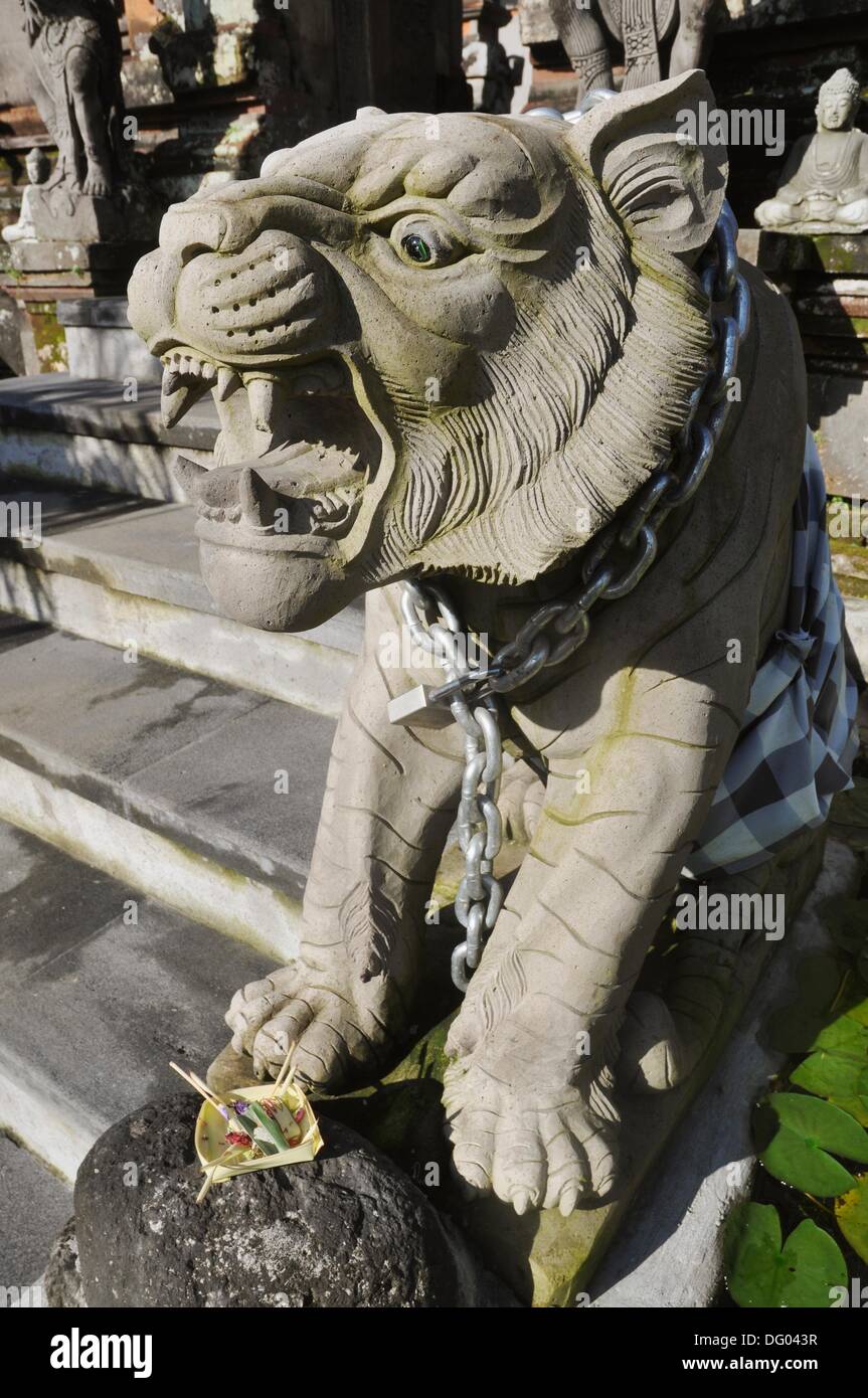 Ubud (Bali, Indonesien): eine Tiger´s Statue, mit einer dicken Kette als eine Leine, am Eingang des einen Hindu-Tempel Stockfoto