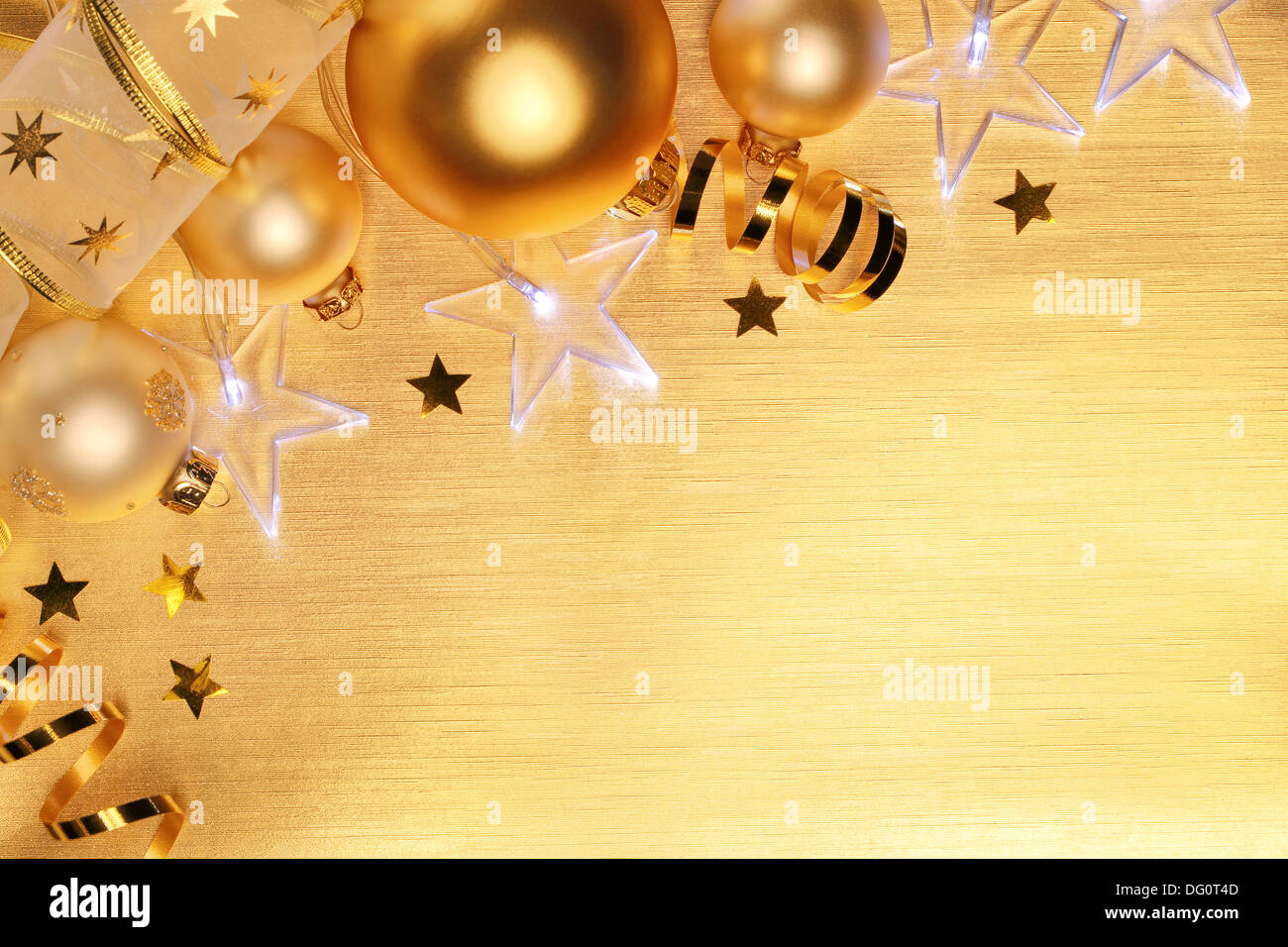 Weihnachtskugeln und Sterne leuchten auf goldenem Hintergrund Stockfoto
