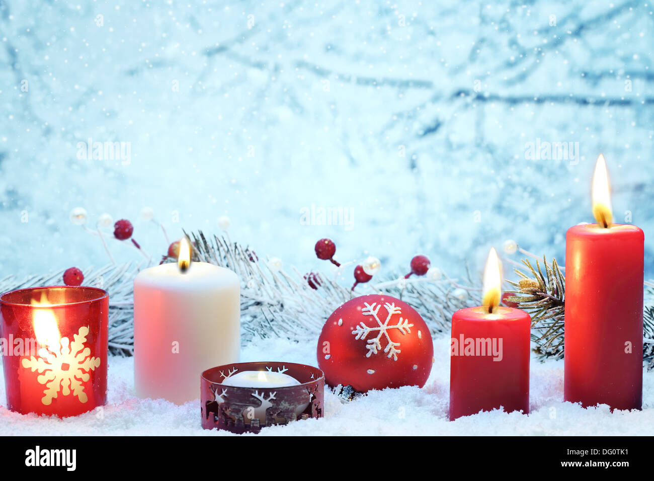Weihnachts-Dekoration mit Kerzen und Ball auf Schnee. Stockfoto