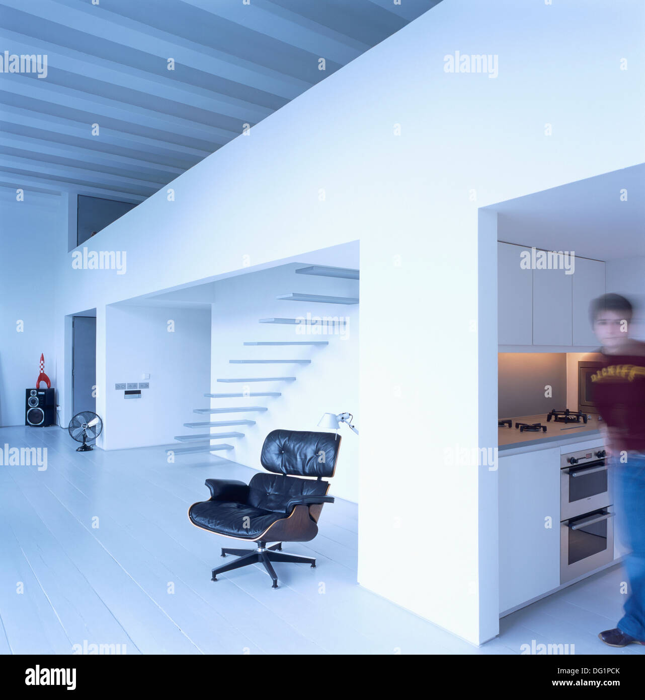Soft-Fokus Figur stehend in der Küche große offene Wohnung mit Charles Eames schwarzen Ledersessel lounge Stockfoto