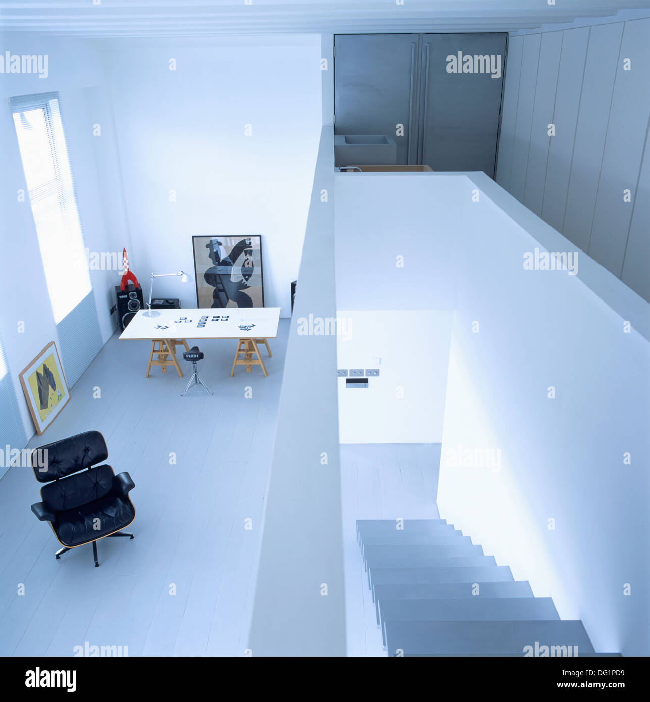 Charles Eames Liege Stuhl in Studie mit Tapeziertisch in Studie über Treppe in offene Stadtwohnung Landung Stockfoto