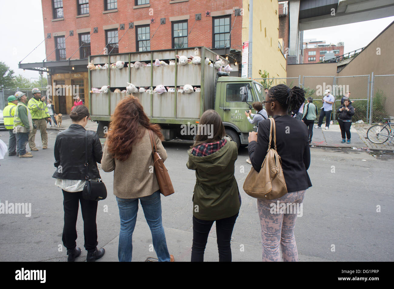 New York City, NY, USA. 11. Oktober 2013. Banksy Fans strömen in trendigen Meatpacking District in New York am Freitag, 11. Oktober 2013, die elfte Ausgabe von Banksys Kunst, "The Sirens of the Lambs" zu sehen. Dieses besondere skulpturale Stück besteht aus einem Schlachthof LKW gefüllt mit blöken Plüschtiere, gesteuert von Puppenspielern, die um von einem Fahrer betrieben wurden, die im Charakter geblieben. Bildnachweis: Richard Levine/Alamy Live-Nachrichten Stockfoto