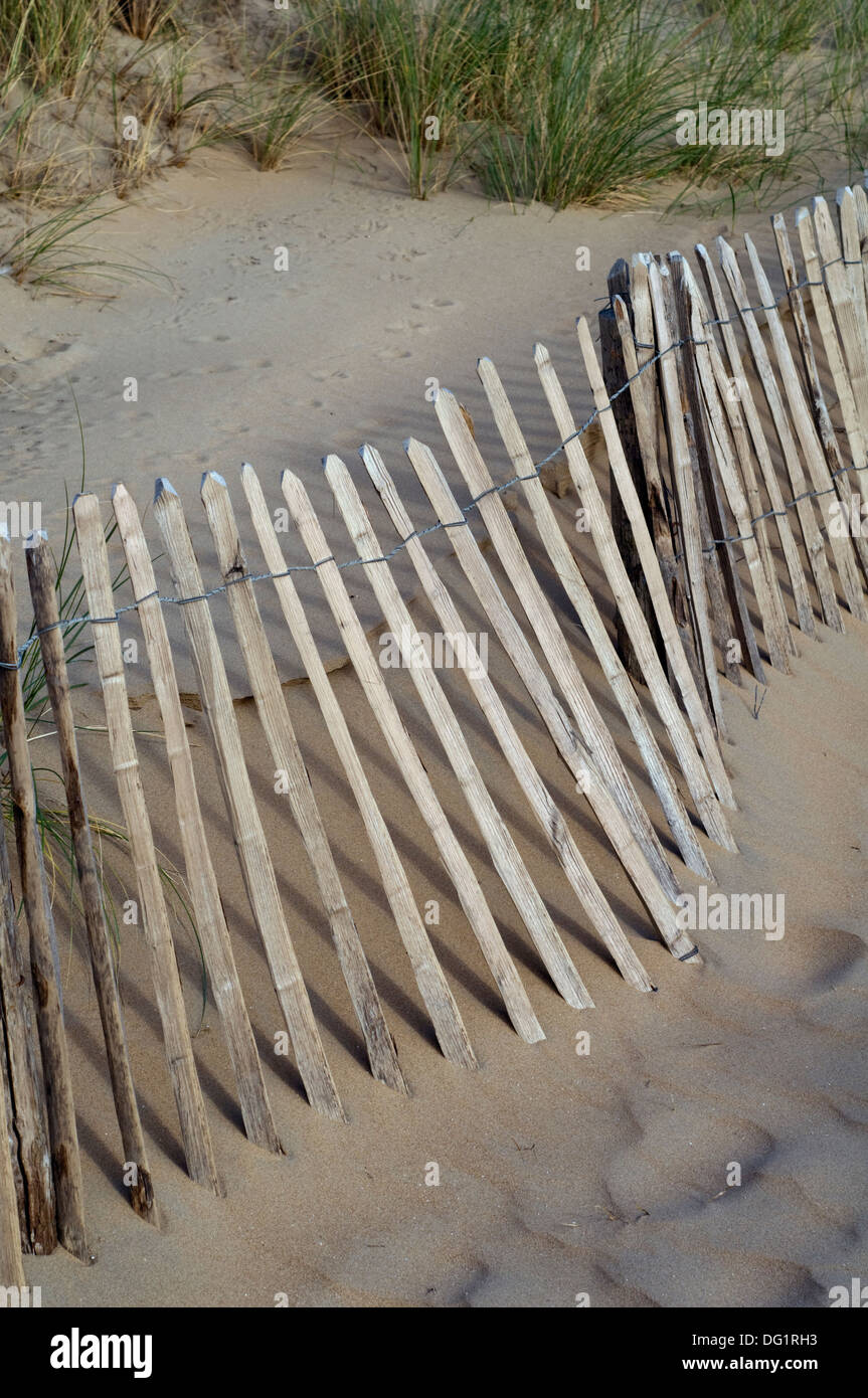 Eine wackelige Holzzaun am Sandstrand Stockfoto