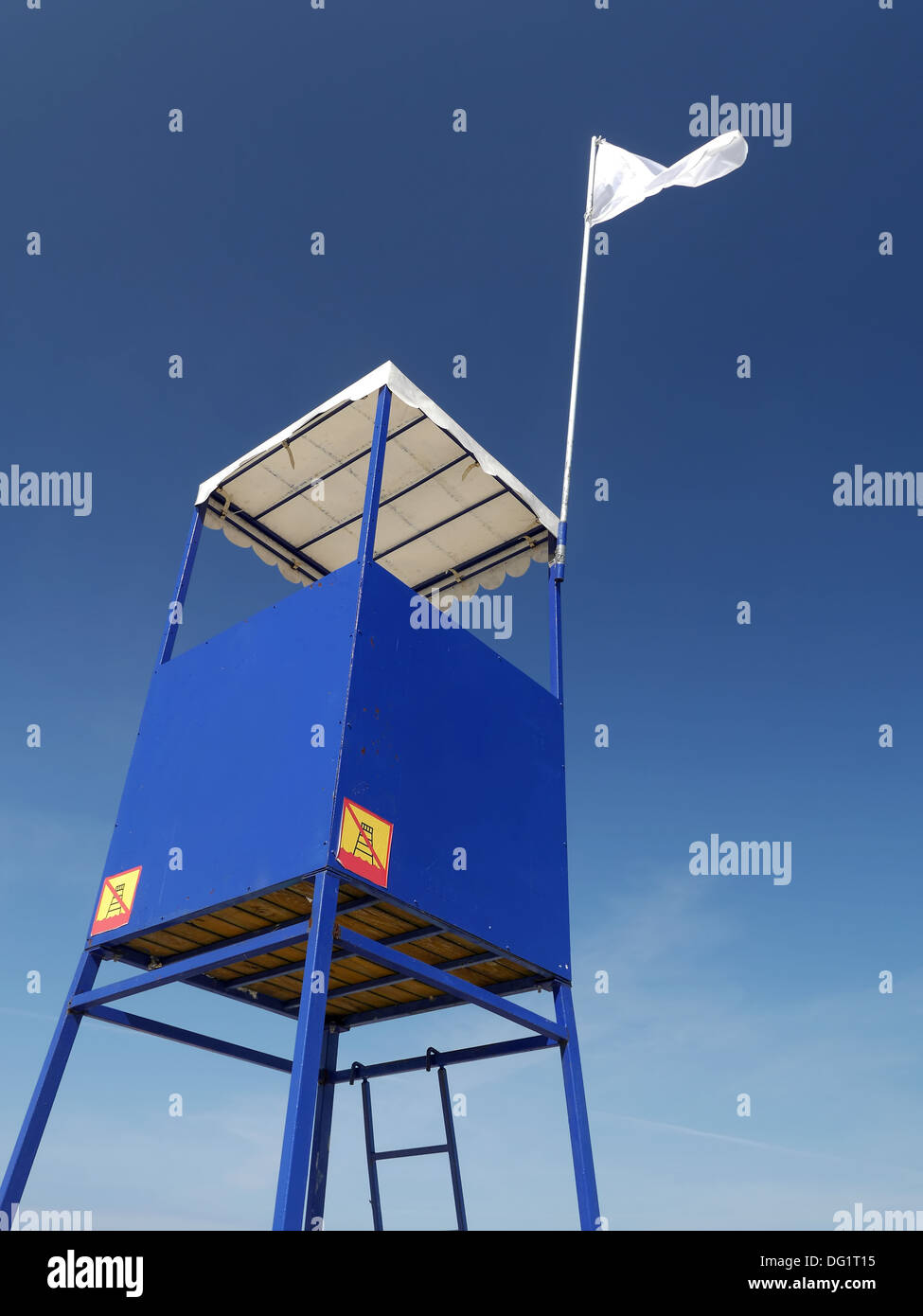 Blaue Rettungsschwimmer-Turm mit weißen Fahne über klaren, blauen Himmel Stockfoto