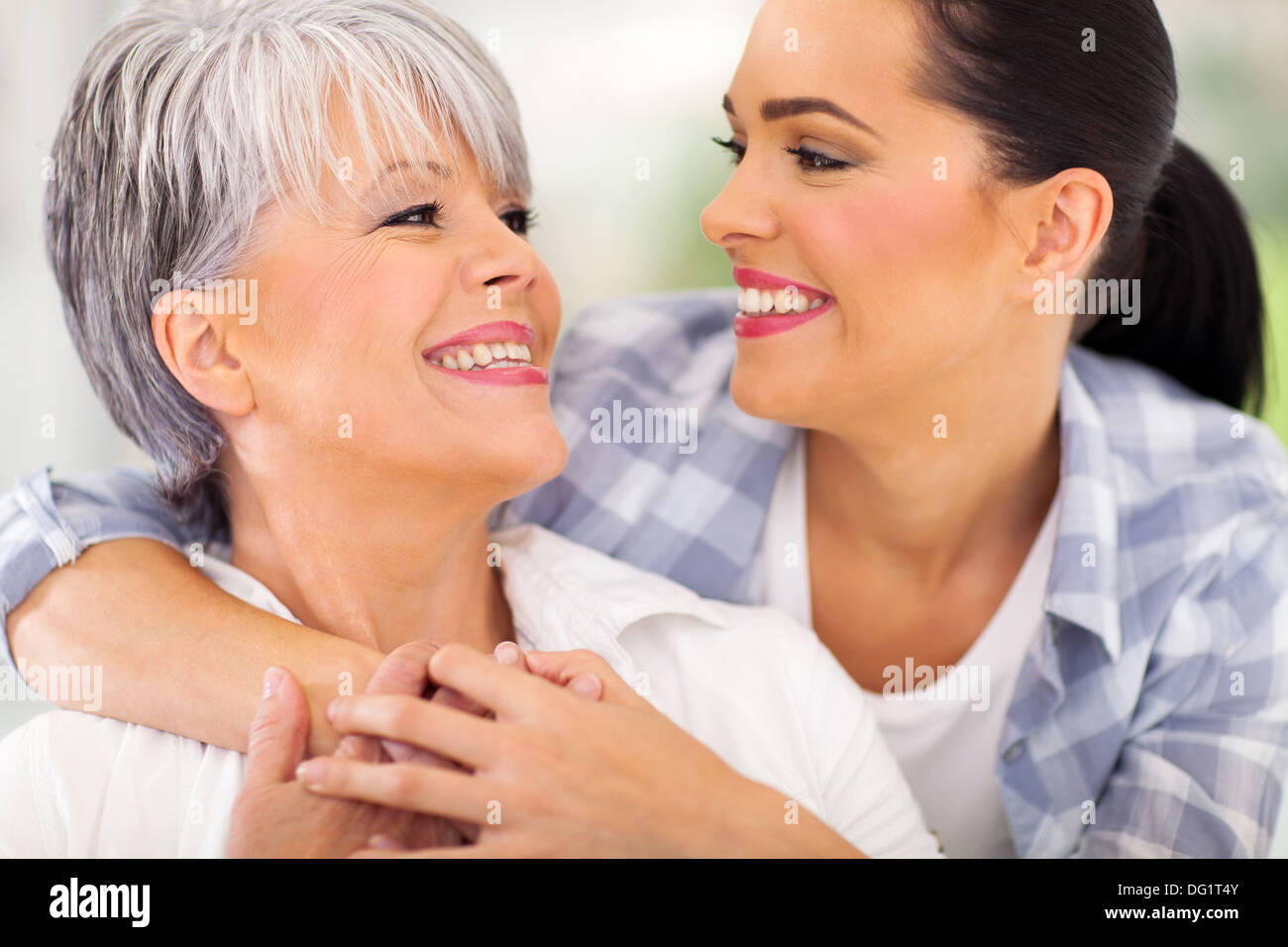 fröhlich im mittleren Alter Mutter und junge Erwachsene Tochter sahen einander Stockfoto