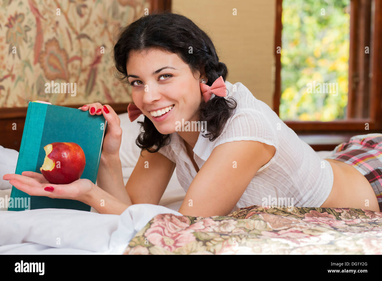 Frau zeigen halb angebissene Apfel und hell Lächeln Stockfoto