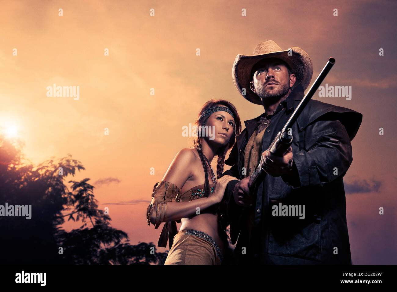 Cowboy und Indianer Frau mit Gewehr vor Sonnenuntergang Stockfoto