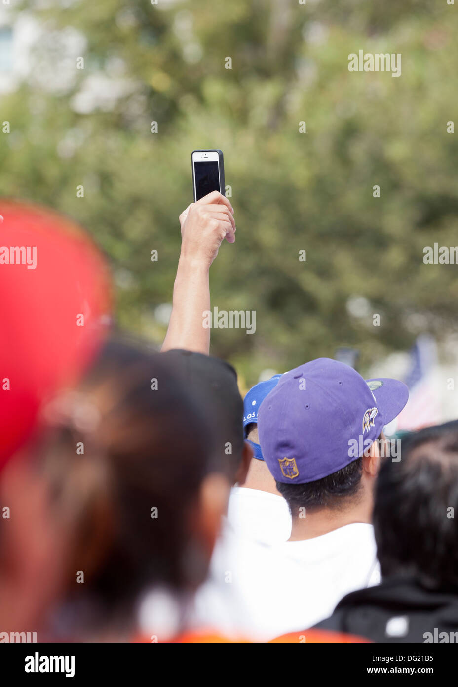 Mann mit einem iPhone Video tape ein outdoor-Event in Menschenmenge Stockfoto